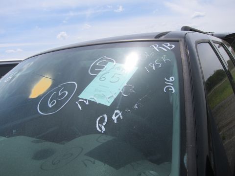 1991 Ford LTD Crown Victoria - Windshield markings and inspection tag on a black vehicle under a partly cloudy sky.