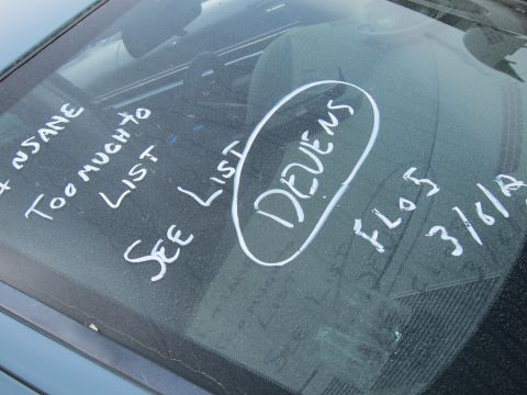 1991 Ford LTD Crown Victoria - Writing on the inside of a car's windshield indicates a long list of issues and a date.