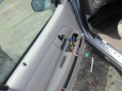 1991 Ford LTD Crown Victoria - The interior door panel of a car has been removed, exposing the electrical wiring and connectors.