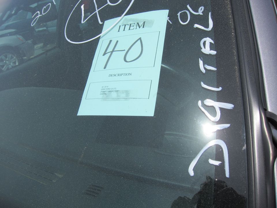 Windshield with auction tag item 40, handwritten notes '2006' and 'DIGITALE', and another vehicle visible through the glass
