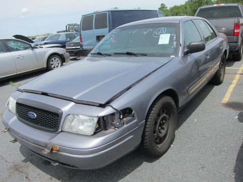 1991 Ford LTD Crown Victoria - Front view of a damaged gray Ford Crown Victoria parked in a lot with other vehicles.