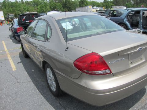 1991 Ford LTD Crown Victoria - Rear view of a tan Ford Taurus SE sedan parked in a lot with other vehicles.