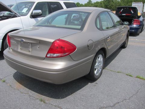 1991 Ford LTD Crown Victoria - A tan Ford Taurus is parked on asphalt with other vehicles nearby.