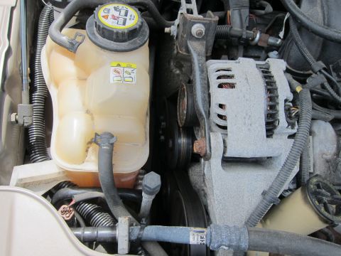 1991 Ford LTD Crown Victoria - Engine bay components including the coolant reservoir and alternator are visible in this close-up shot.
