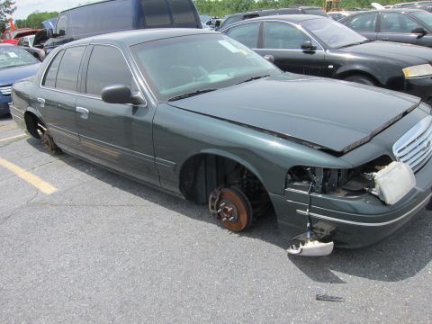 1991 Ford LTD Crown Victoria - This Ford Crown Victoria is missing all four wheels and has damage to its front bumper and headlight assembly.