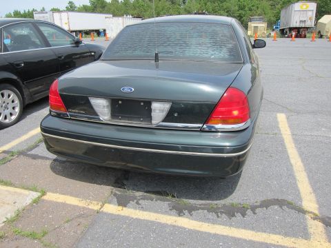 1991 Ford LTD Crown Victoria - Rear view of a dark green 1991 Ford Crown Victoria LTD, with the "Crown Victoria" badge clearly visible on the trunk lid.