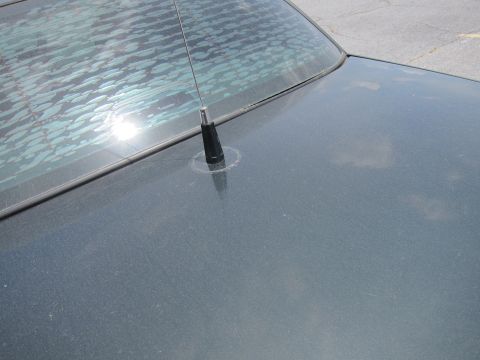 1991 Ford LTD Crown Victoria - Rear view of a car's deck lid and antenna, with a partially defrosted rear window.