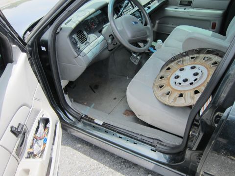 1991 Ford LTD Crown Victoria - The interior of a 1991 Ford Crown Victoria LTD is shown with a hubcap resting on the passenger seat.