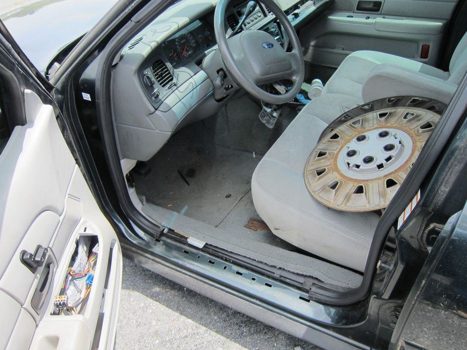 Interior of a 1991 Ford Crown Victoria LTD showing the dashboard, steering wheel, and passenger seat with a hubcap on it