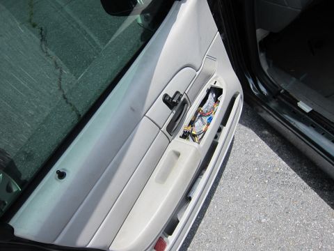 1991 Ford LTD Crown Victoria - Interior view of a car door panel showing exposed electrical components and wiring.