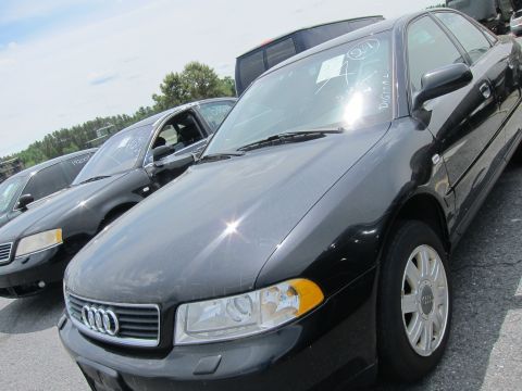 1991 Ford LTD Crown Victoria - Multiple black sedans are parked in an outdoor lot under a bright sky.