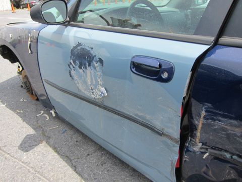 1991 Ford LTD Crown Victoria - Side view of a damaged light blue car door with a missing front fender and visible interior components.