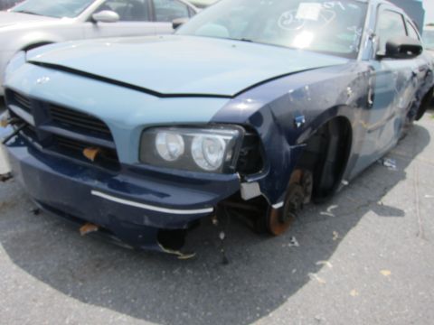 1991 Ford LTD Crown Victoria - Damaged Dodge Charger in a lot, with another vehicle visible behind it.