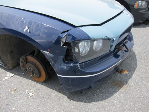 1991 Ford LTD Crown Victoria - A damaged police car sits without a front wheel, showing the word POLICE on its fender.