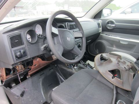 1991 Ford LTD Crown Victoria - Car interior shows dashboard, steering wheel, and exposed wiring; a hubcap rests on the seat.