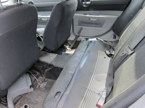 1991 Ford LTD Crown Victoria - The interior of a car shows the back seats and floor, with some parts appearing to be disassembled.