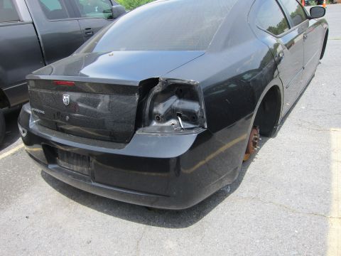 1991 Ford LTD Crown Victoria - Rear view of a black Dodge Charger missing its rear passenger taillight and both rear wheels.