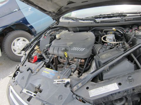 1991 Ford LTD Crown Victoria - Engine bay detail showing the 3500 V6 engine cover and part of a blue van.