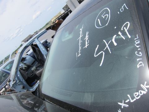 1991 Ford LTD Crown Victoria - Several vehicles sit in a junkyard, with markings on the windshields indicating parts or condition.