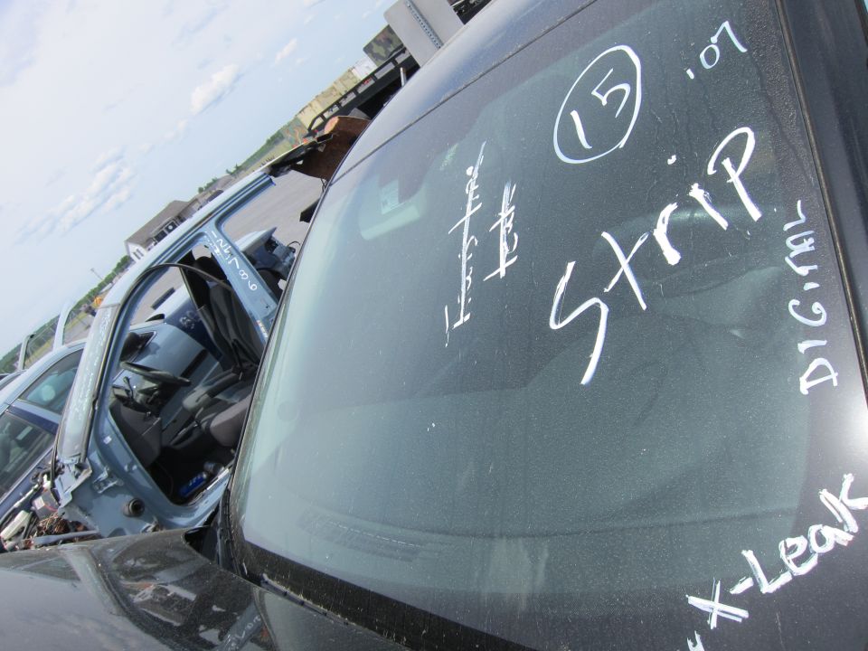 Cars in a junkyard with writing on the windshields