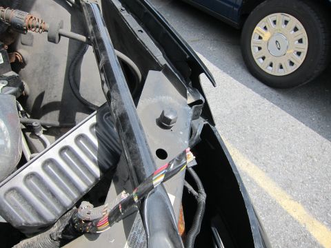 1991 Ford LTD Crown Victoria - Close-up view of the engine bay, revealing wiring harnesses and a portion of a blue vehicle in the background.