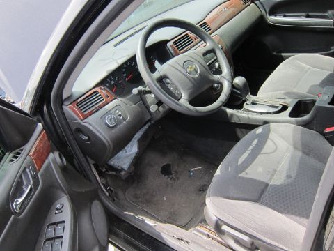 1991 Ford LTD Crown Victoria - The interior of a car shows wear and tear, with a visible Chevrolet emblem on the steering wheel.