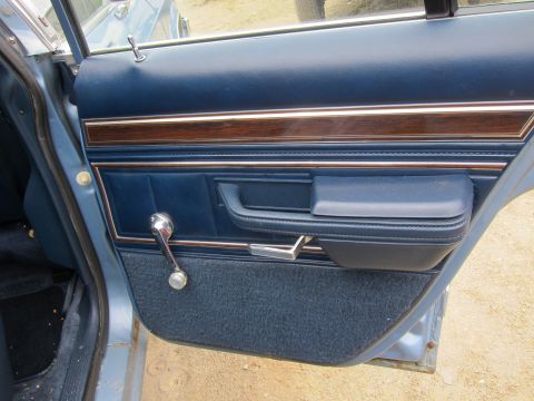 2001 Ford Crown Victoria - Interior door panel detail with chrome window crank and wood trim.