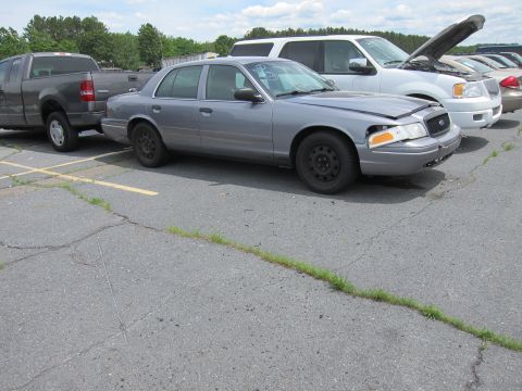 1991 Ford LTD Crown Victoria - A gray Ford Crown Victoria sedan is parked in a lot next to other vehicles, with its front passenger side showing damage.