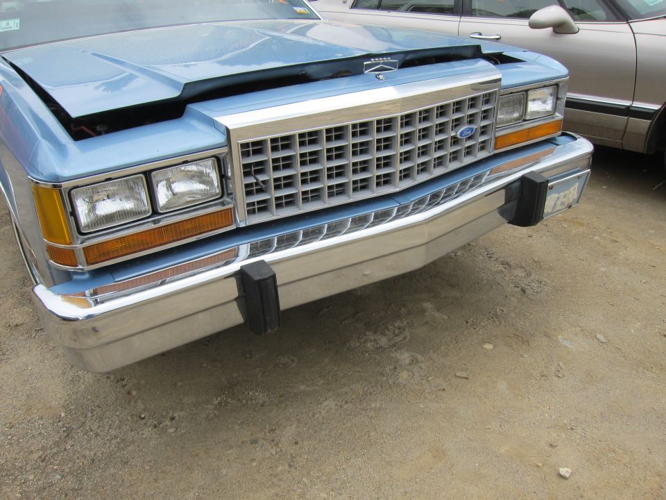 Blue sedan front grille and headlights, chrome bumper