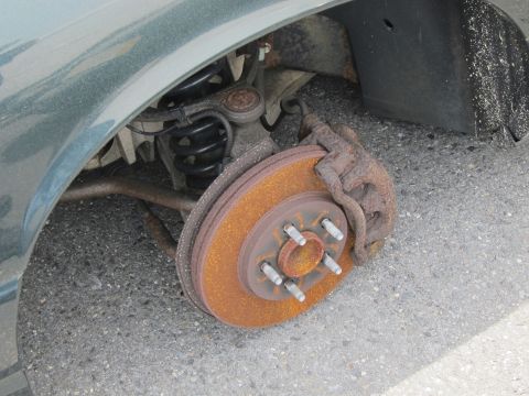 1991 Ford LTD Crown Victoria - The brake system shows significant rust on the rotor and caliper components.