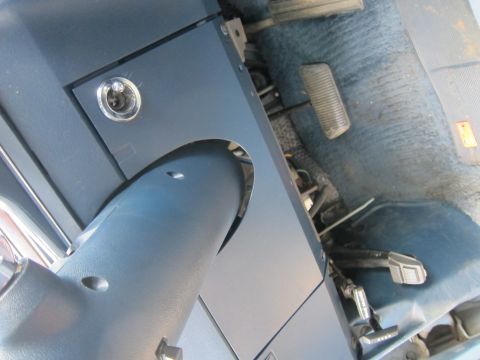 2001 Ford Crown Victoria - The interior of a vehicle shows the steering column, pedals, and blue carpeted floor.