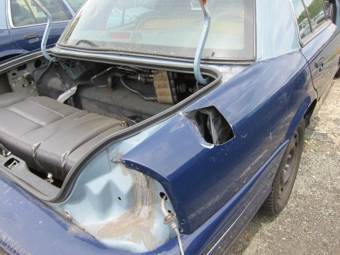 1991 Ford LTD Crown Victoria - Rear view of a 1991 Ford Crown Victoria LTD, showing trunk interior and damage to the right rear quarter panel.