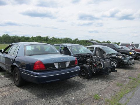 1991 Ford LTD Crown Victoria - Multiple vehicles are lined up in an outdoor lot under a cloudy sky.
