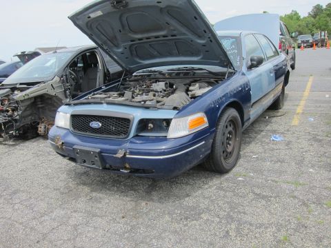 1991 Ford LTD Crown Victoria - Front view of a blue Ford Crown Victoria sedan with its hood open, parked next to a damaged vehicle.