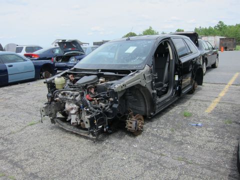 1991 Ford LTD Crown Victoria - This heavily damaged SUV is missing its front bumper, hood, and headlights, with exposed engine parts and no wheels.