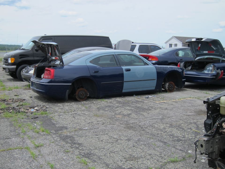 Two-tone blue Dodge Charger with missing wheels and hood open