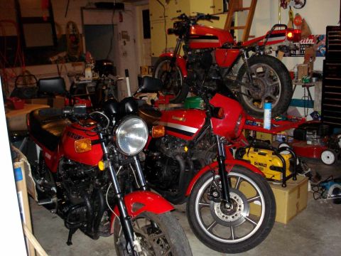 2008 Ford Crown Victoria - Several red motorcycles are parked inside a cluttered garage, with tools and other items visible.