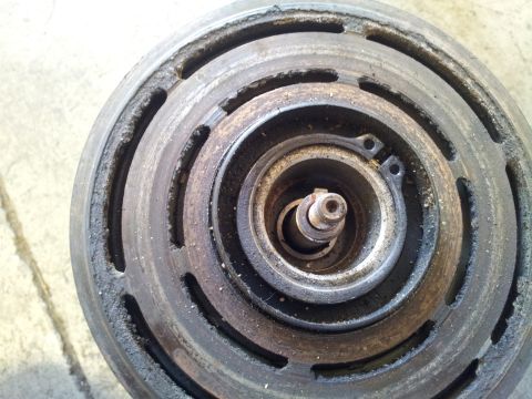 2005 Chevrolet Venture - A close-up view of a used air conditioning compressor clutch, showing signs of wear and tear.