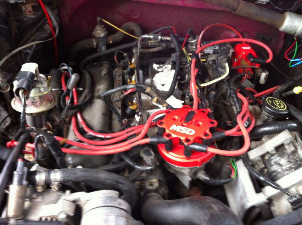 As you can see I plugged all of the intake holes with paper towel's so I could scrape the old gasket off and not drop anything in it. I also re-routed my plug wires so they looked much better and had less of a chance of cross-ignition. If you look closely you can see the new injectors in place.