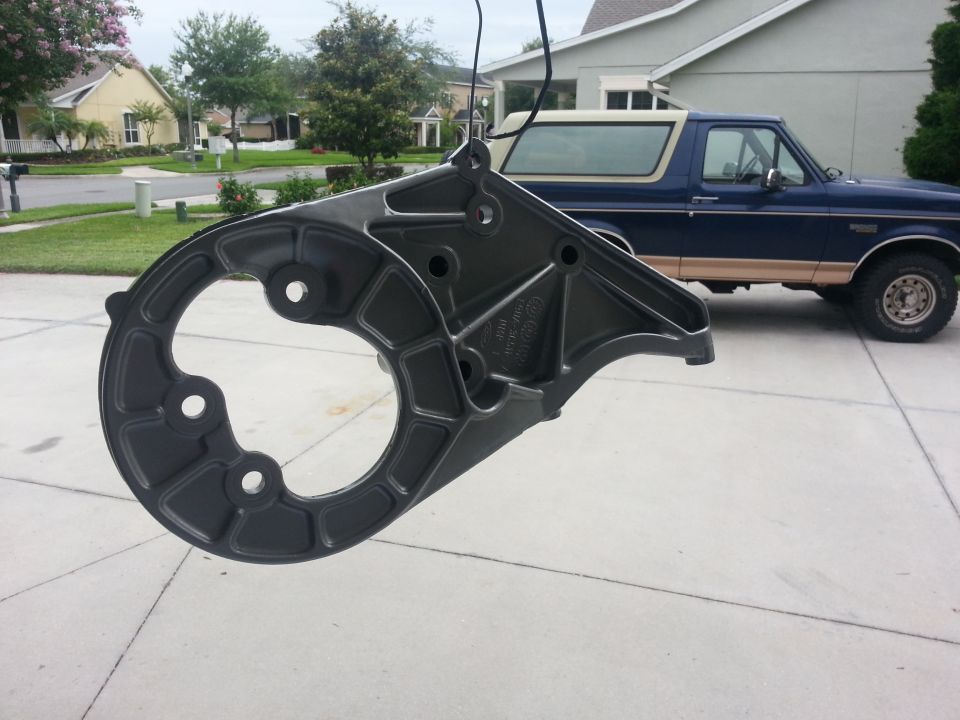 Gray metal part in foreground, blue 1994 Ford Bronco in background