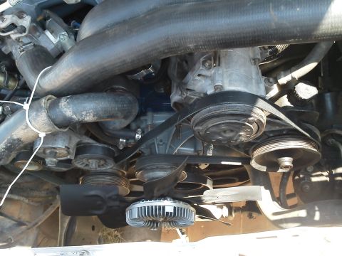 1988 Ford Bronco - Close-up view of the engine bay, highlighting the serpentine belt, pulleys, and cooling fan assembly.