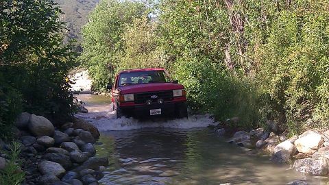 1988 Ford Bronco - Red 1992 Ford Bronco navigates a rocky stream during a cleanup event.
