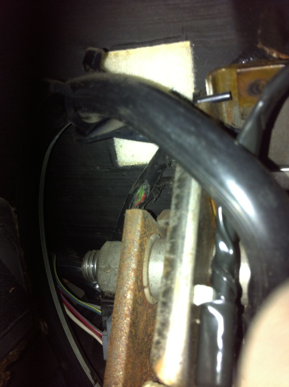 Close-up of brake light switch assembly with wires and mounting bracket