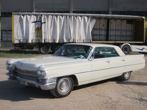 1991 Ford Crown Victoria - A classic Cadillac sedan with prominent tail fins is parked outdoors.