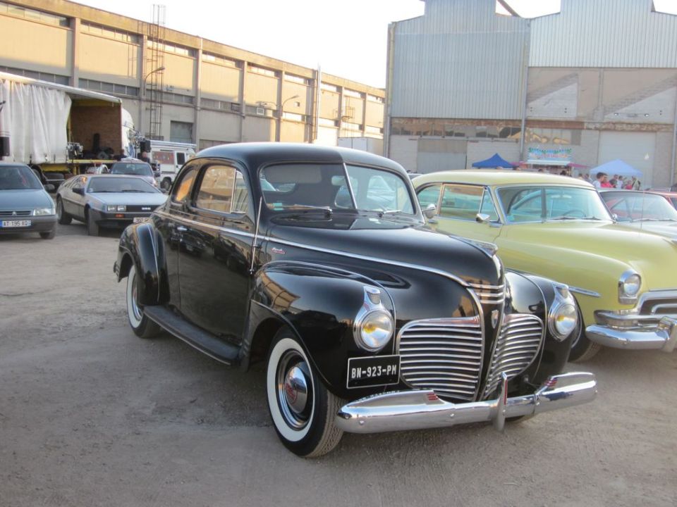 Black 1940s coupe with chrome grille and whitewall tires