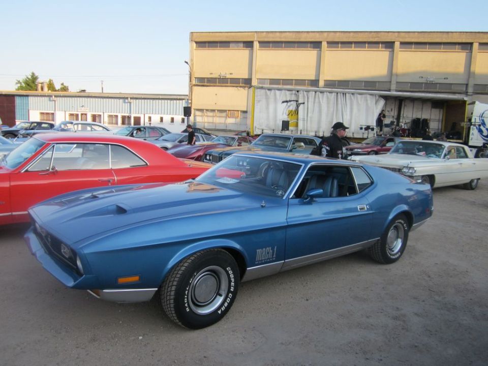 Blue 1971 Ford Mustang Mach 1 coupe with a scoop on the hood, parked outdoors