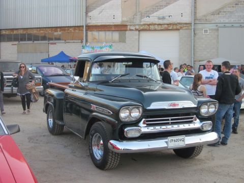 1991 Ford Crown Victoria - A classic Chevrolet pickup truck is displayed outdoors with spectators gathered around.