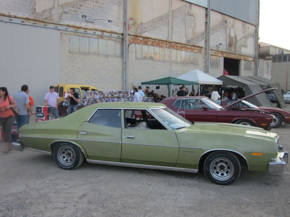 Green sedan with chrome trim and aftermarket wheels, parked outdoors