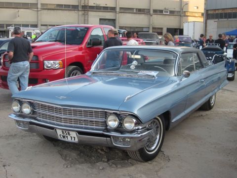 1991 Ford Crown Victoria - A light blue 1960 Cadillac Coupe de Ville is parked outdoors with other vehicles visible.