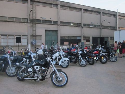 1991 Ford Crown Victoria - A collection of motorcycles are parked in front of a large industrial building.